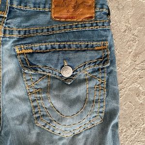 Men’s True religion jeans with thick stitching and light wash